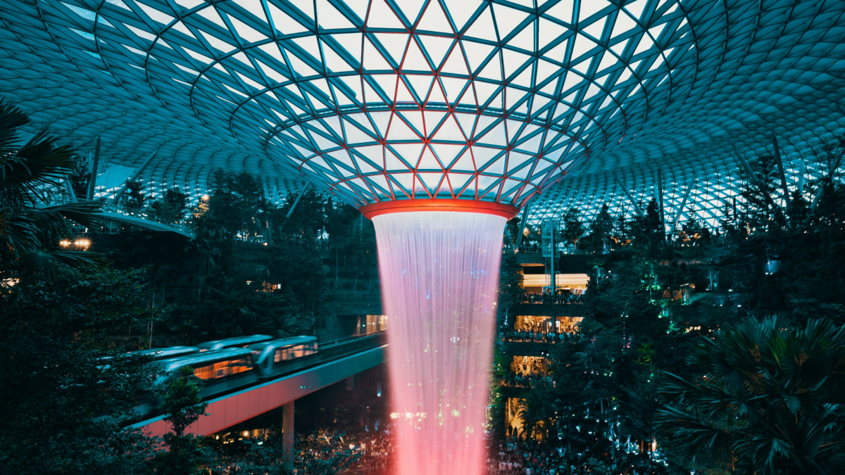 Indoor waterfall surrounded by trees in a dome