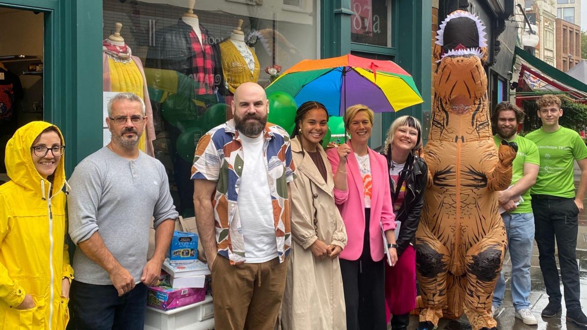 group picture with a man wearing a dinosaur costume