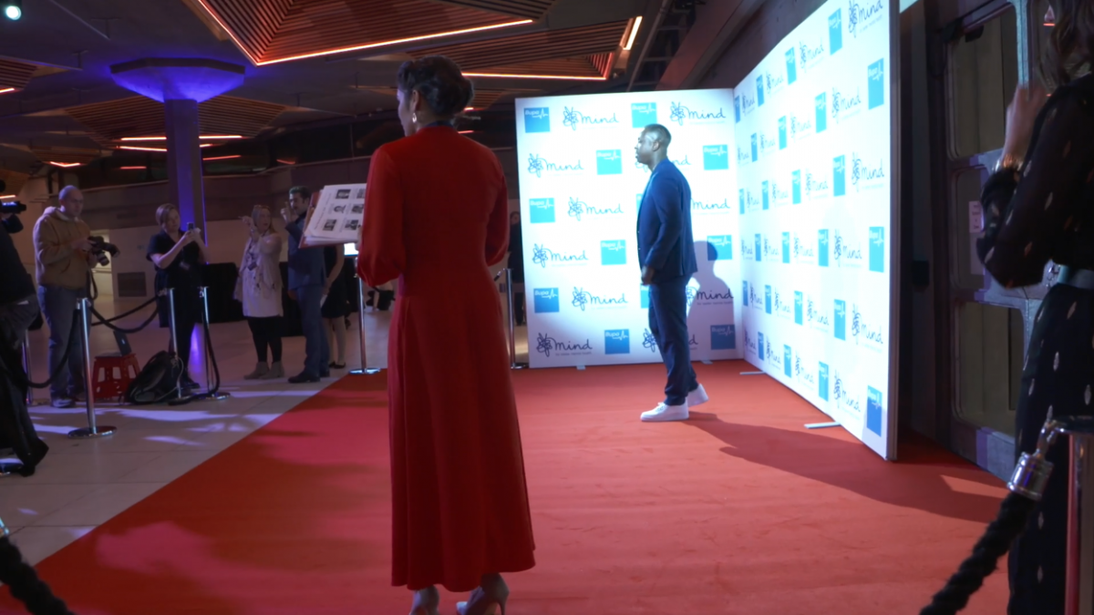 Two people having a photograph taken on a red carpet