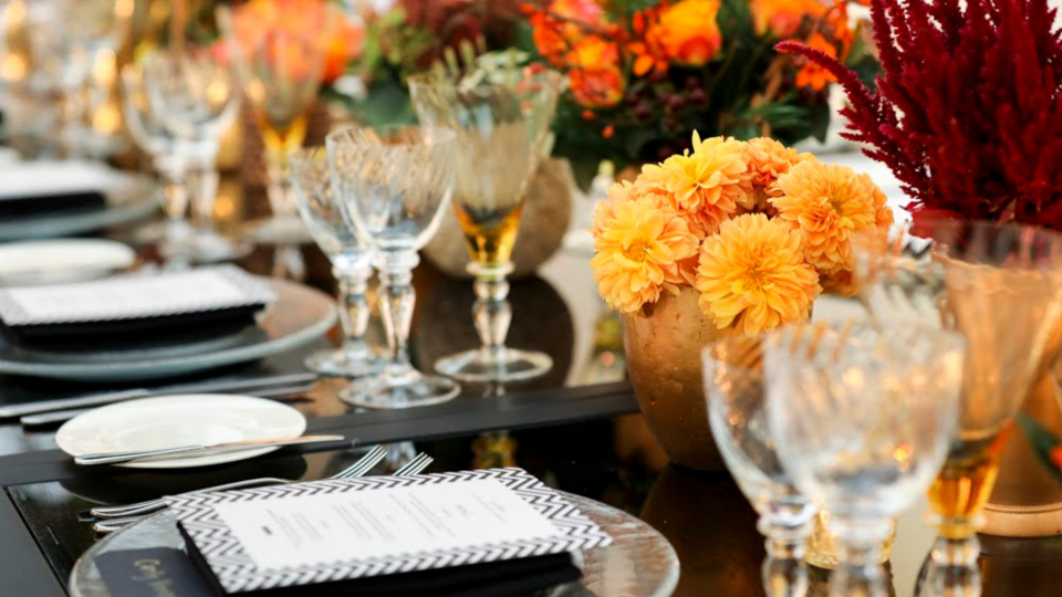 table setting with orange and red flower centrepieces